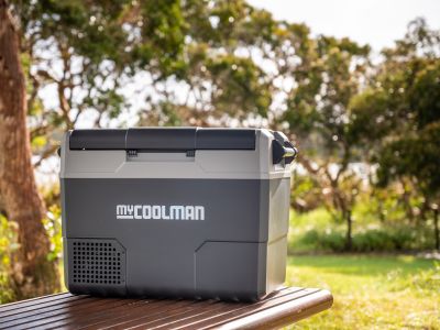 myCOOLMAN cool box on a picnic bench in a sunny summer field — portable cooler in real-world use – Complete Buying Guide: myCOOLMAN Coolers & Ice Boxes