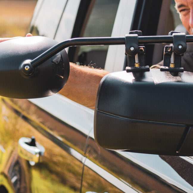 Towing mirror being adjusted by a driver outdoors — Milenco towing mirrors in real-world use – Complete Towing Mirror Guide: Aero Adjustable Blind Spot Mirror Review