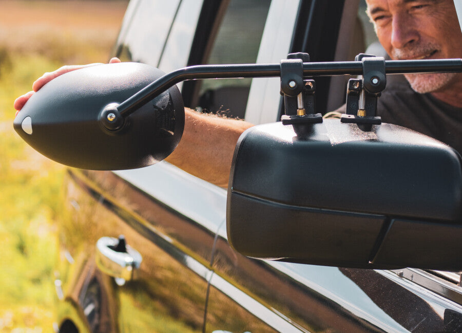 Towing mirror being adjusted by a driver outdoors — Milenco towing mirrors in real-world use – Complete Towing Mirror Guide: Aero Adjustable Blind Spot Mirror Review