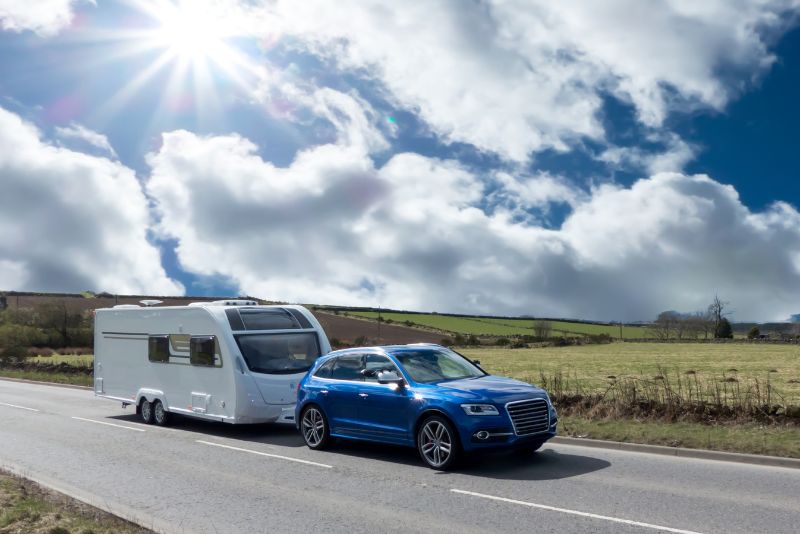 Caravan being towed along a country road — safe and stable touring with proper towing setup – Why Milenco MGI Wedge Level with Chock – Single Ramp + Matching Wheel Chock – Wide-Base, High-Grip is Essential for Safe Towing