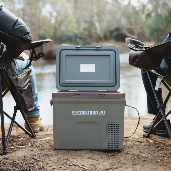 myCOOLMAN cooler placed between two camping chairs outdoors — lifestyle scene of the portable fridge in use – Top 5 myCOOLMAN Dual Zone Fridge / Freezers Every Caravan Owner Needs
